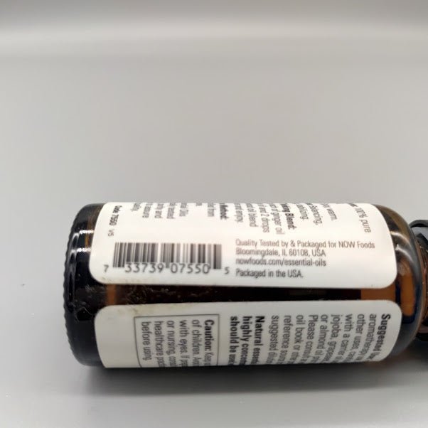 Aceite esencial de jengibre NOW 100% puro Zingiber officinale 1 oz — vista lateral (foto de archivo)