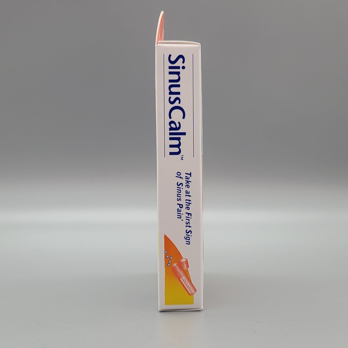 Otro costado de la caja SinusCalm: Take at the First Sign of Sinus Pain* y el tubo de pellets